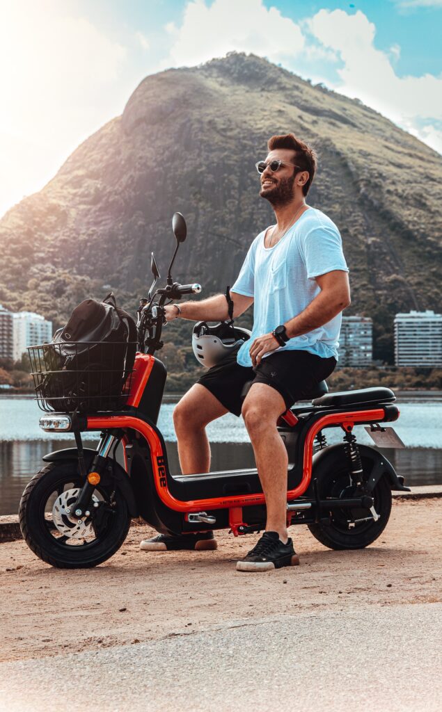 A man sitting on the side of the road on his new red ebike